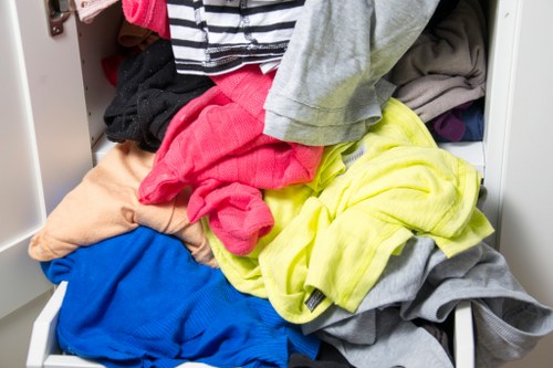 Workers wearing PPE moving waste into a skip